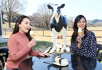 絞りたての新鮮なミルクで作ったソフトクリームを食べている2人